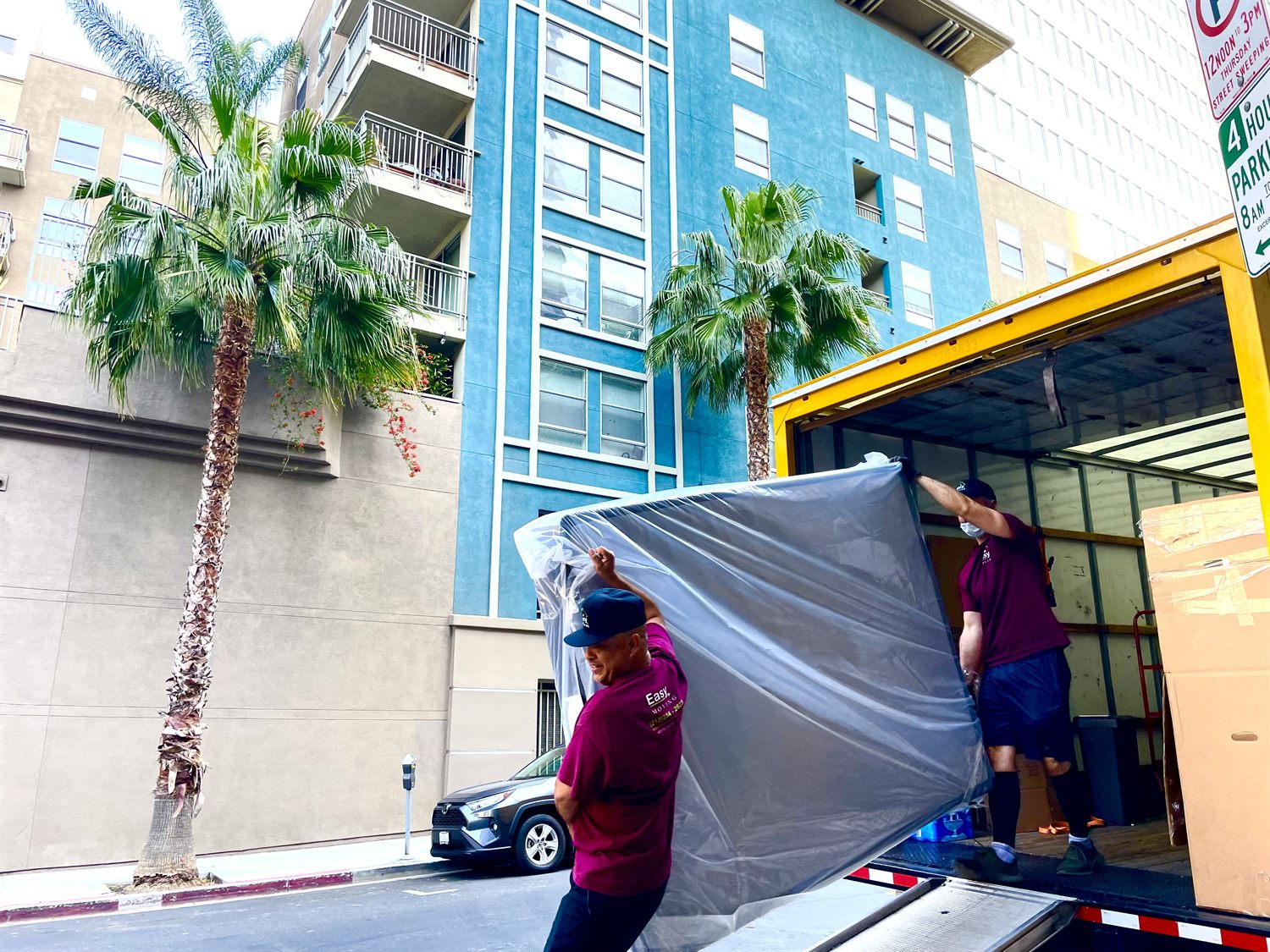 Easy Moving LA crew unloading a protected mattress at a Los Angeles apartment